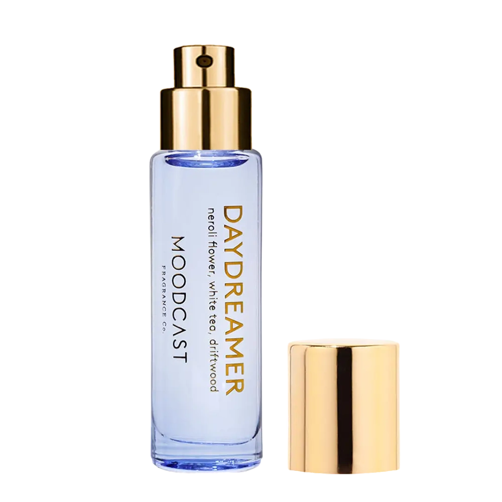 Clear glass perfume bottle with blue liquid, gold spray nozzle, gold lettering, and a detached gold cap.