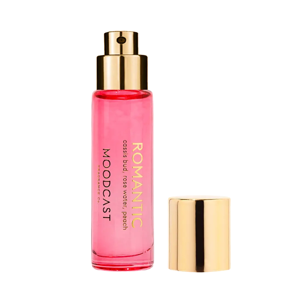 Pink glass perfume mist bottle with a gold spray nozzle and matching cap beside it on a white background.