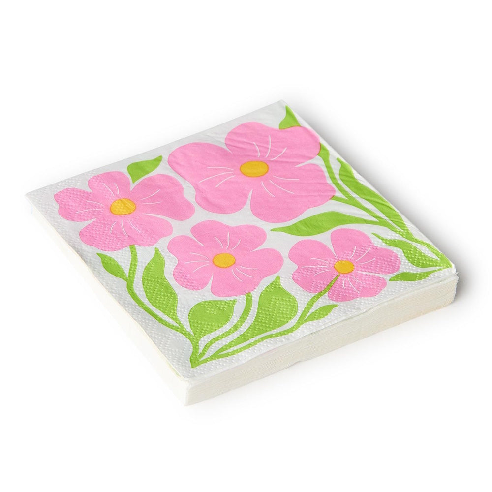 Stack of white paper napkins printed with bright pink flowers, yellow centers, and green leaves.
