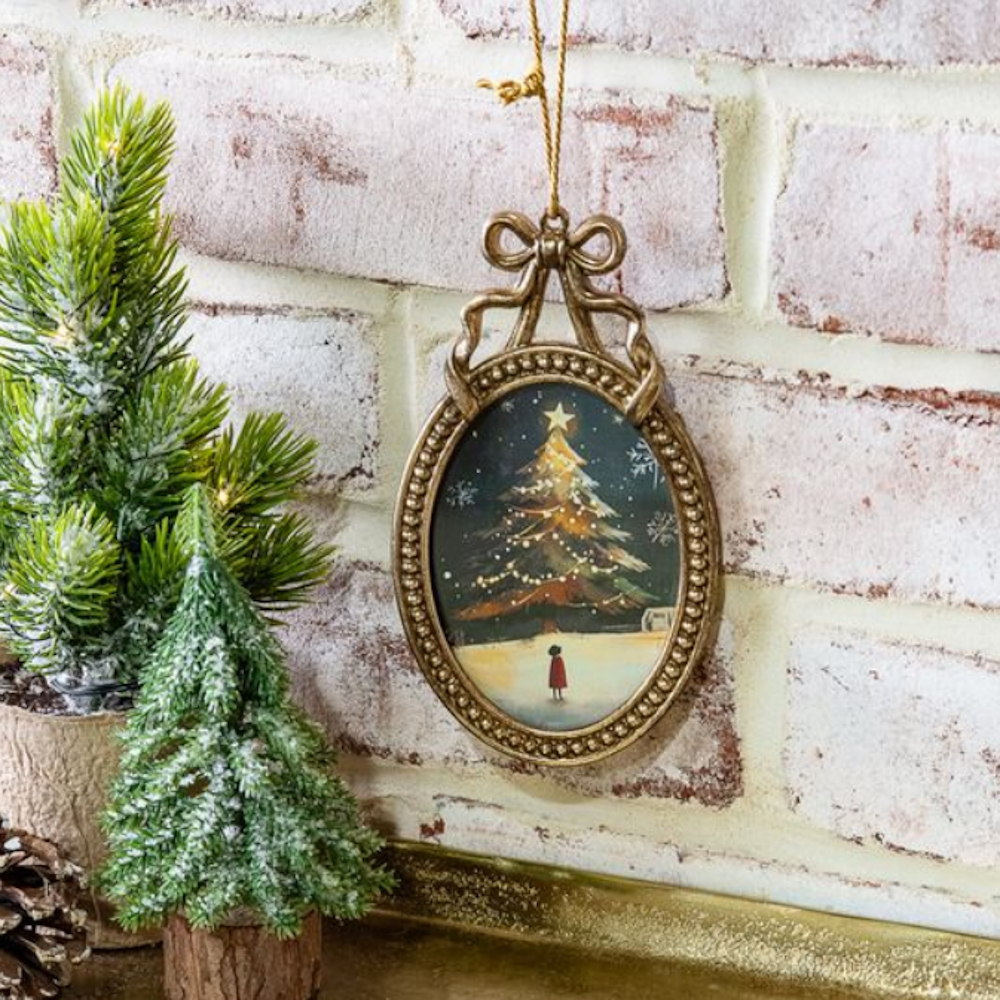 Oval brass-framed ornament topped with a bow, featuring a vintage Christmas tree illustration.