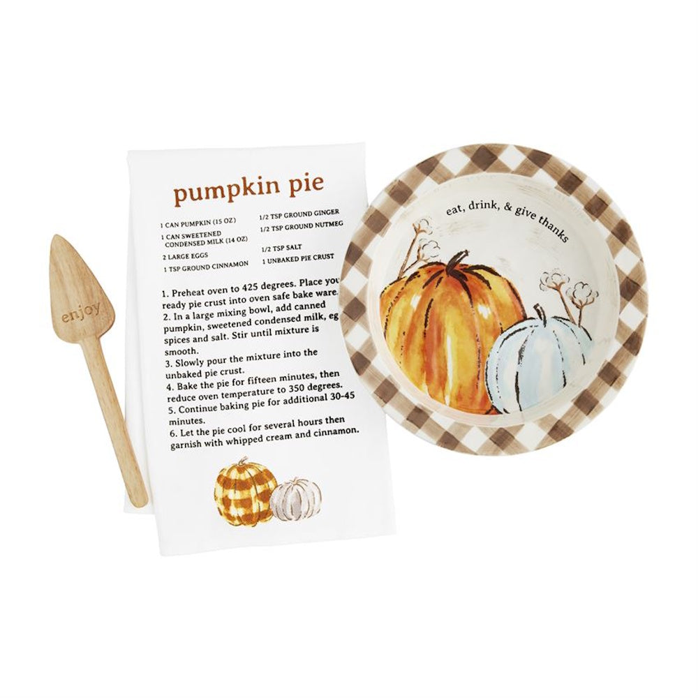 Ceramic pumpkin pie dish set with wooden server and pumpkin pie recipe tea towel.