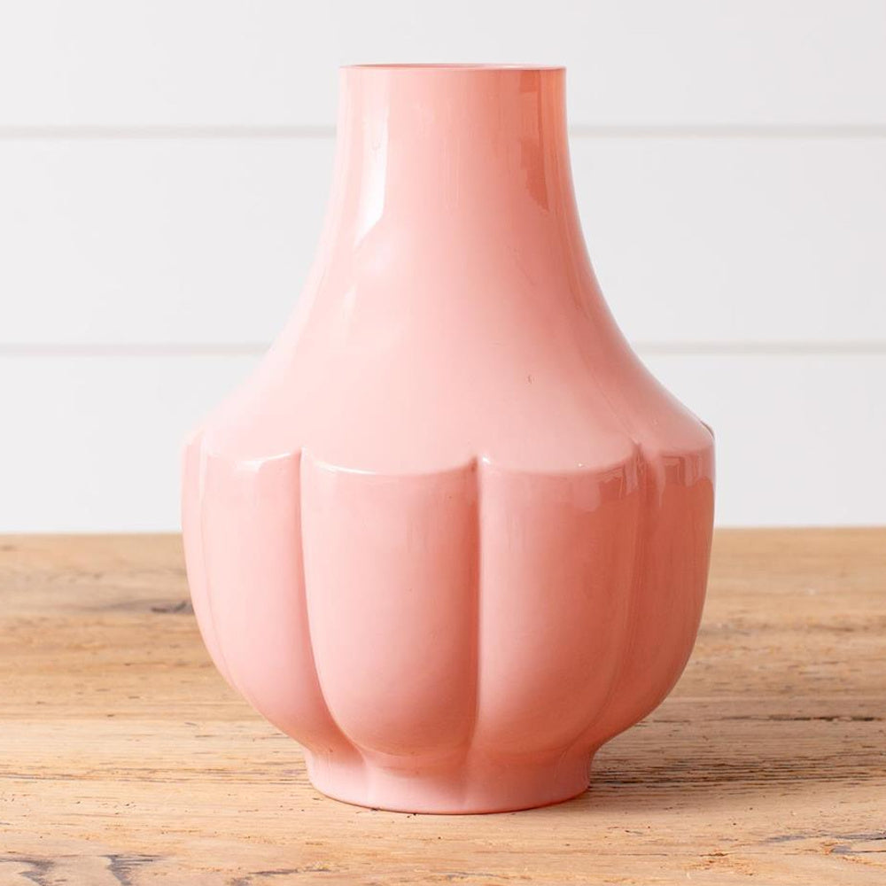 Pink fluted glass vase with a glossy finish and scalloped base, perfect for modern home decor or floral arrangements.