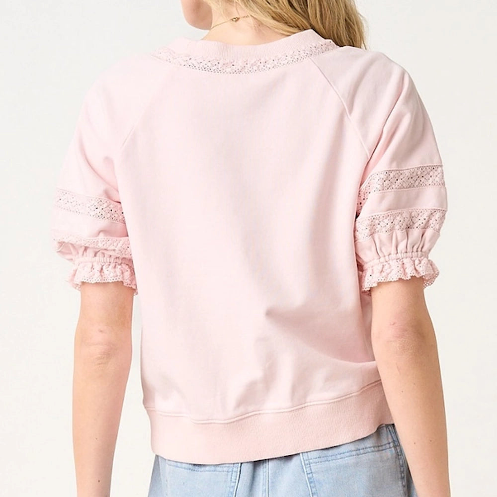 Light pink short puff sleeve top with delicate lace detailing on the neckline and sleeves for a feminine, stylish look.
