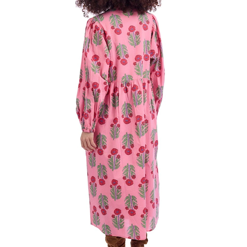 Back view of a pink Pippy midi dress with red and green floral print, long puff sleeves, and a tiered skirt.