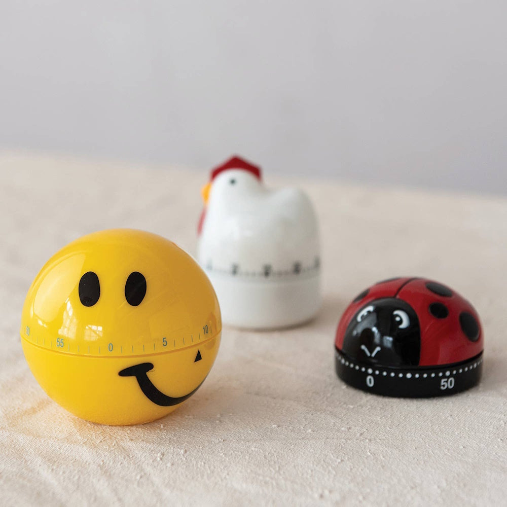 Three novel kitchen timers shaped as a yellow smiley face, a red ladybug, and a white chicken.
