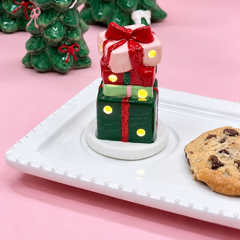 Light-up stacked Christmas presents figurine and a cookie on a white platter.