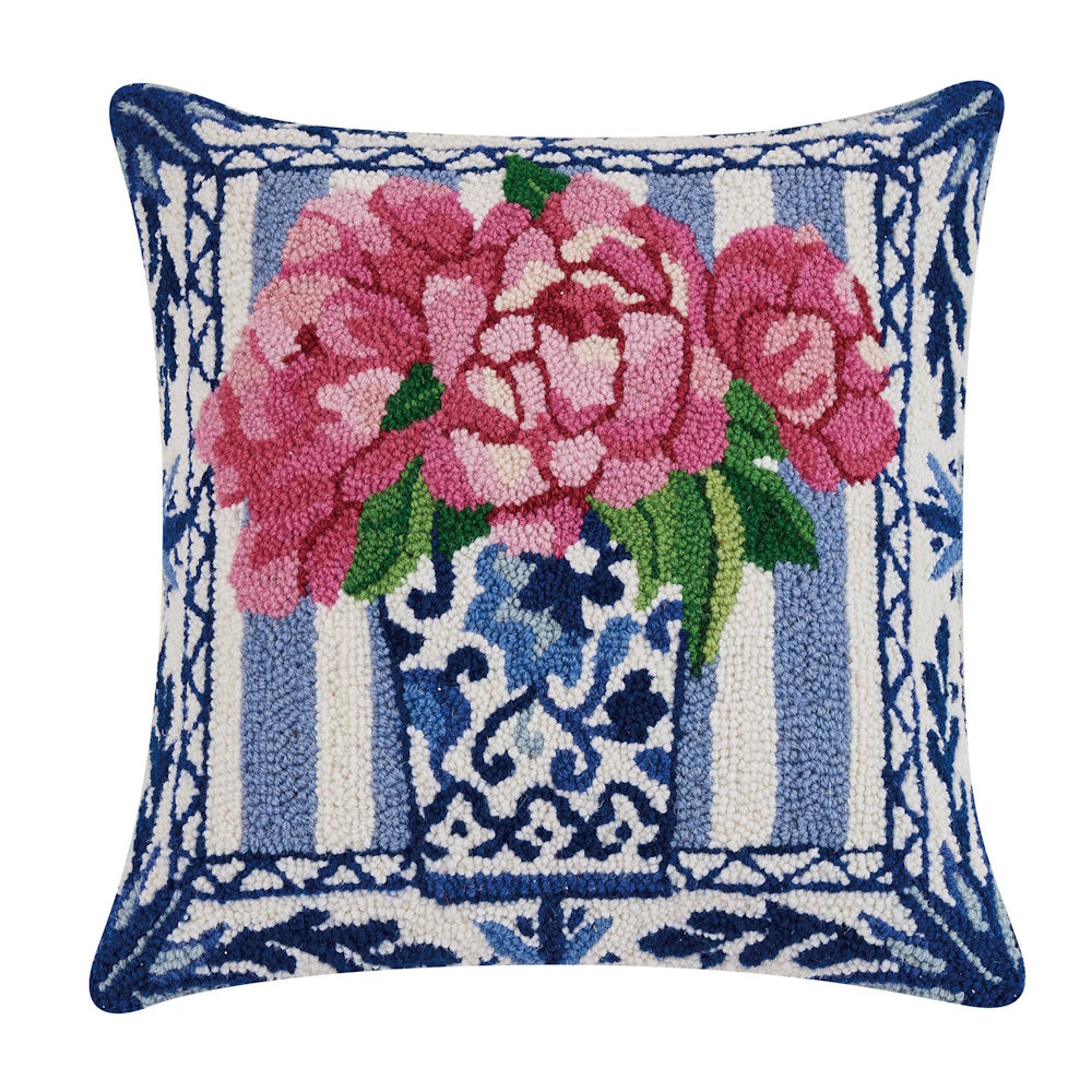 Hand-hooked decorative pillow with pink peonies in a blue and white chinoiserie vase on striped background.