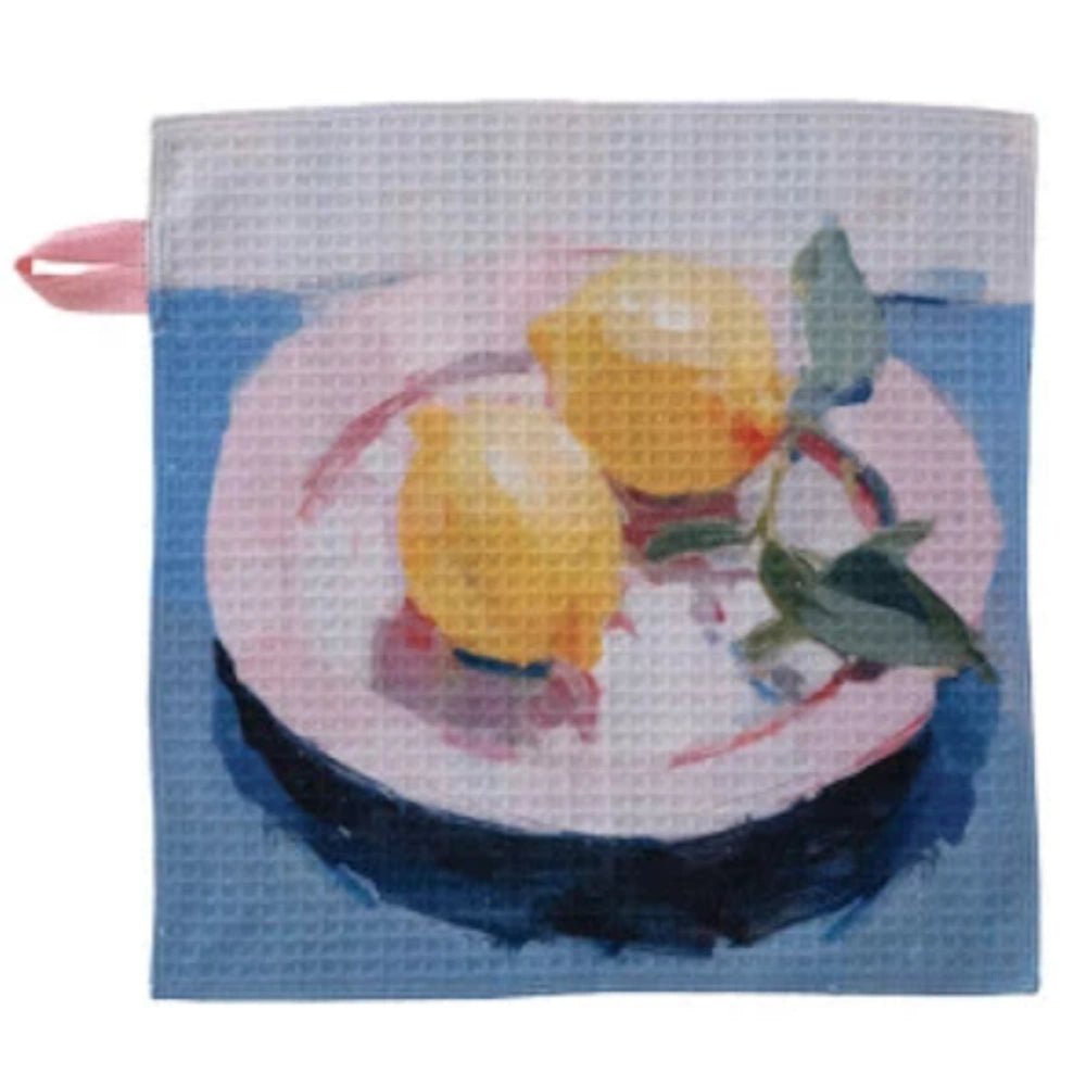 Two lemons on a pink plate illustration on a recycled microfiber two-sided dish cloth with a waffle texture.