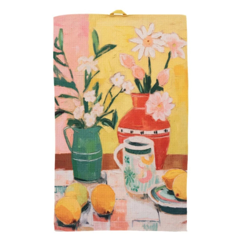 Colorful microfibre tea towel featuring a painted still life of flowers in vases, lemons, and a mug on a yellow background.
