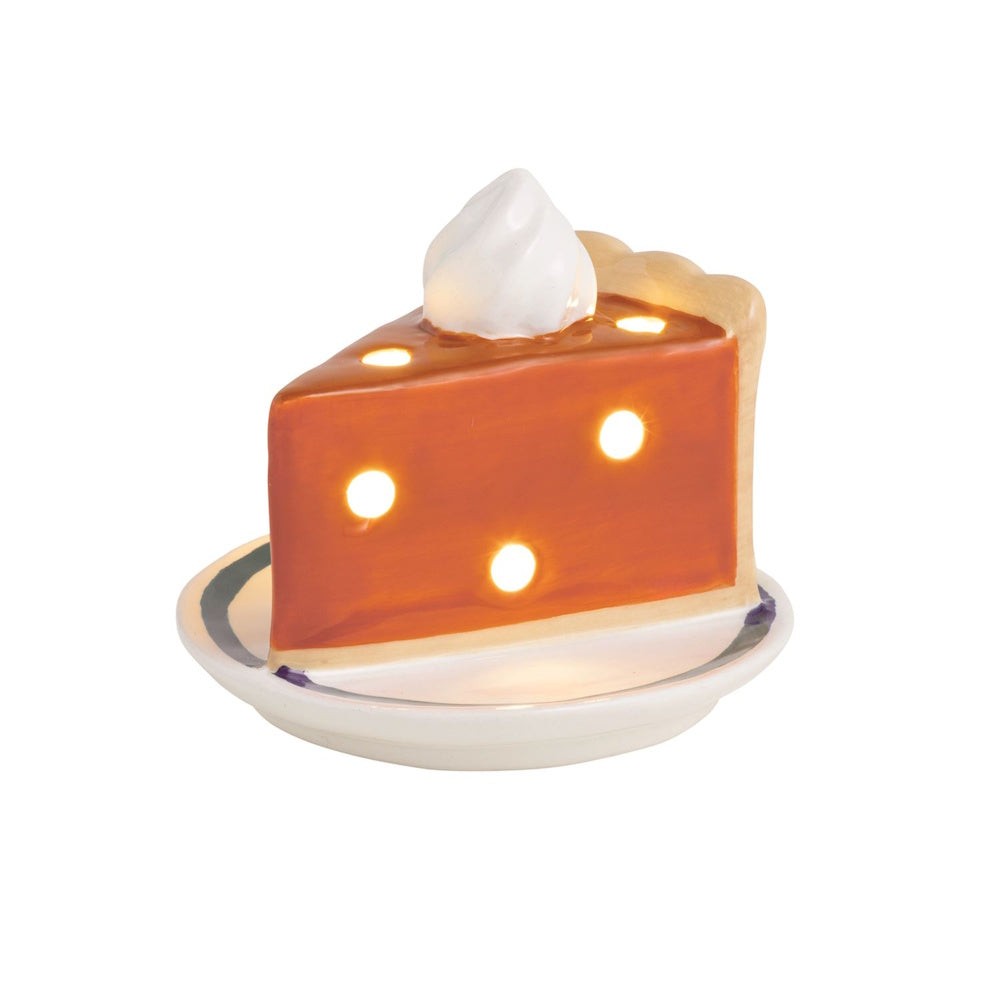 Light-up ceramic pumpkin pie slice with whipped cream on a plate.