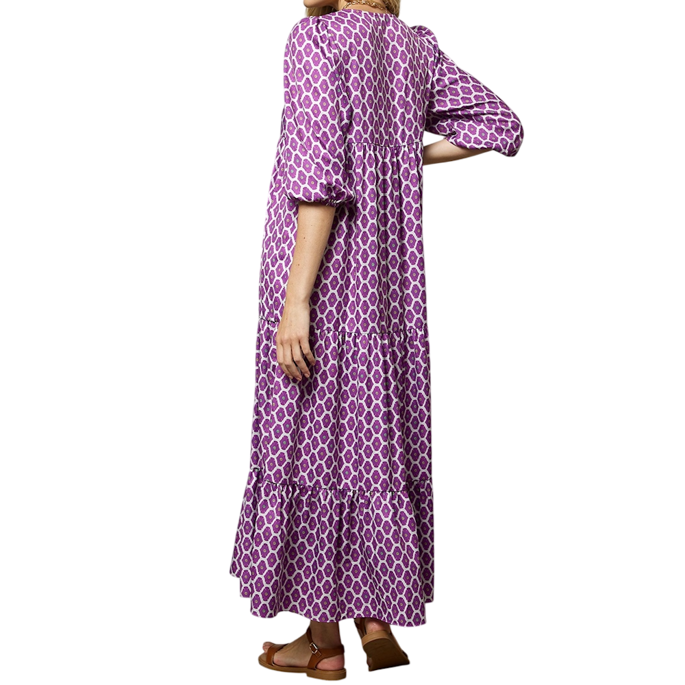 Side view of a person wearing a tiered purple and white patterned maxi dress with three-quarter puff sleeves.