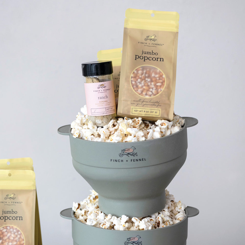 Finch + Fennel ranch seasoning and jumbo popcorn kernels sitting in stacked bowls of popped popcorn.