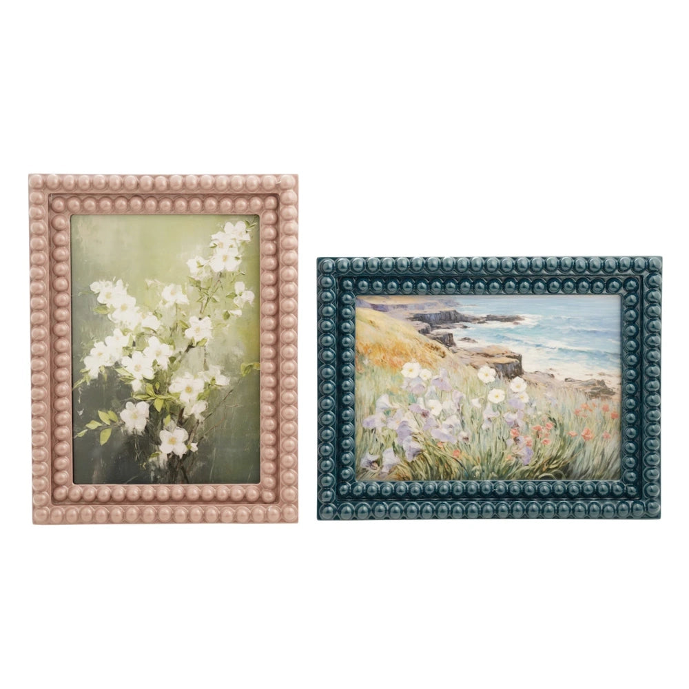 Pink and blue bobbin resin photo frames with beaded borders featuring floral and coastal landscape art prints.