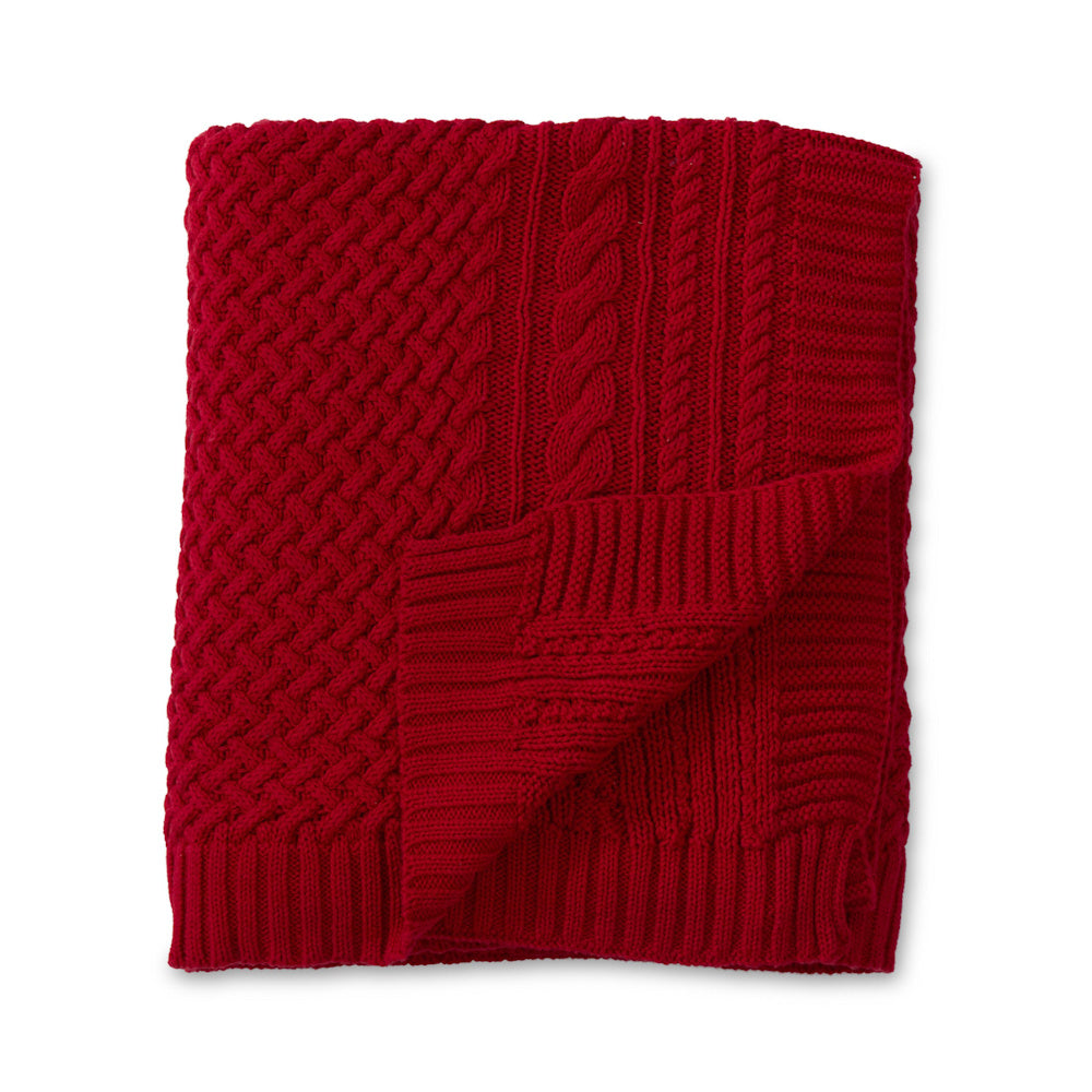 A neatly folded, bright red cable-knit throw blanket with a textured pattern on a white background.
