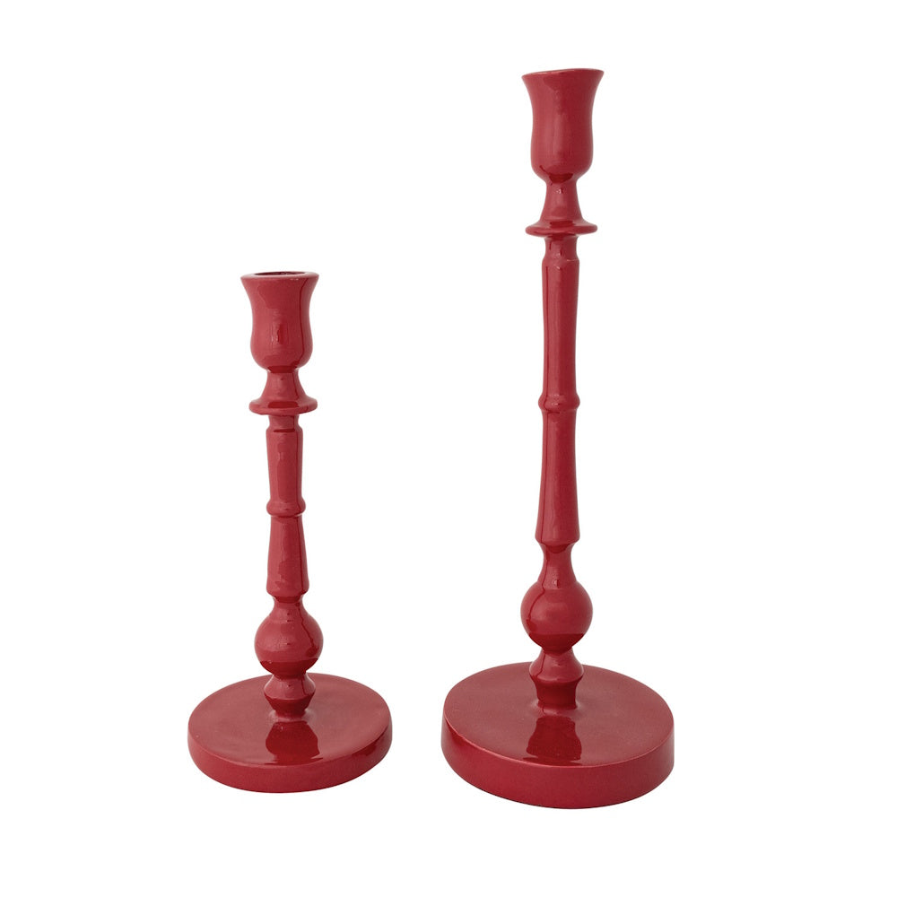 Two red enameled cast aluminum taper candle holders of different heights.