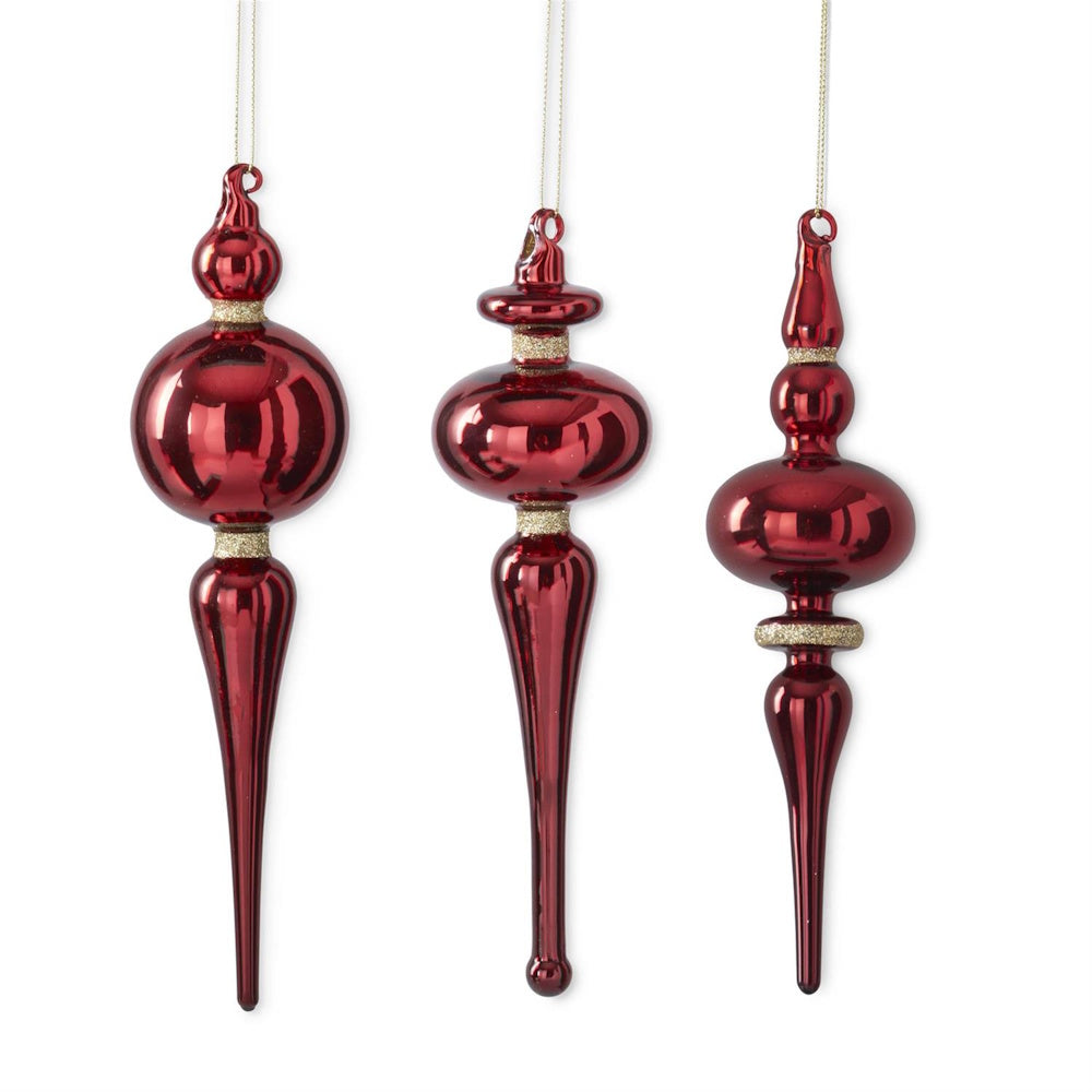 Three hanging red glass finial Christmas ornaments with gold glitter trim.