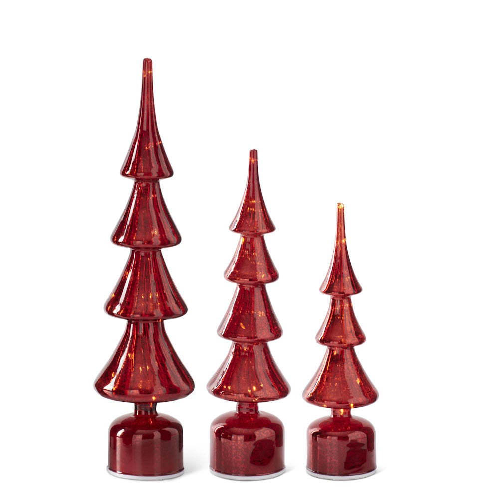 Three illuminated red glass Christmas tree decorations in varying sizes set against a plain white background.