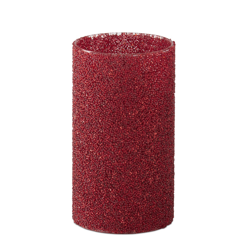 Red glass cylinder candle slip cover textured with a dense layer of small crimson seed beads on a clear glass base.
