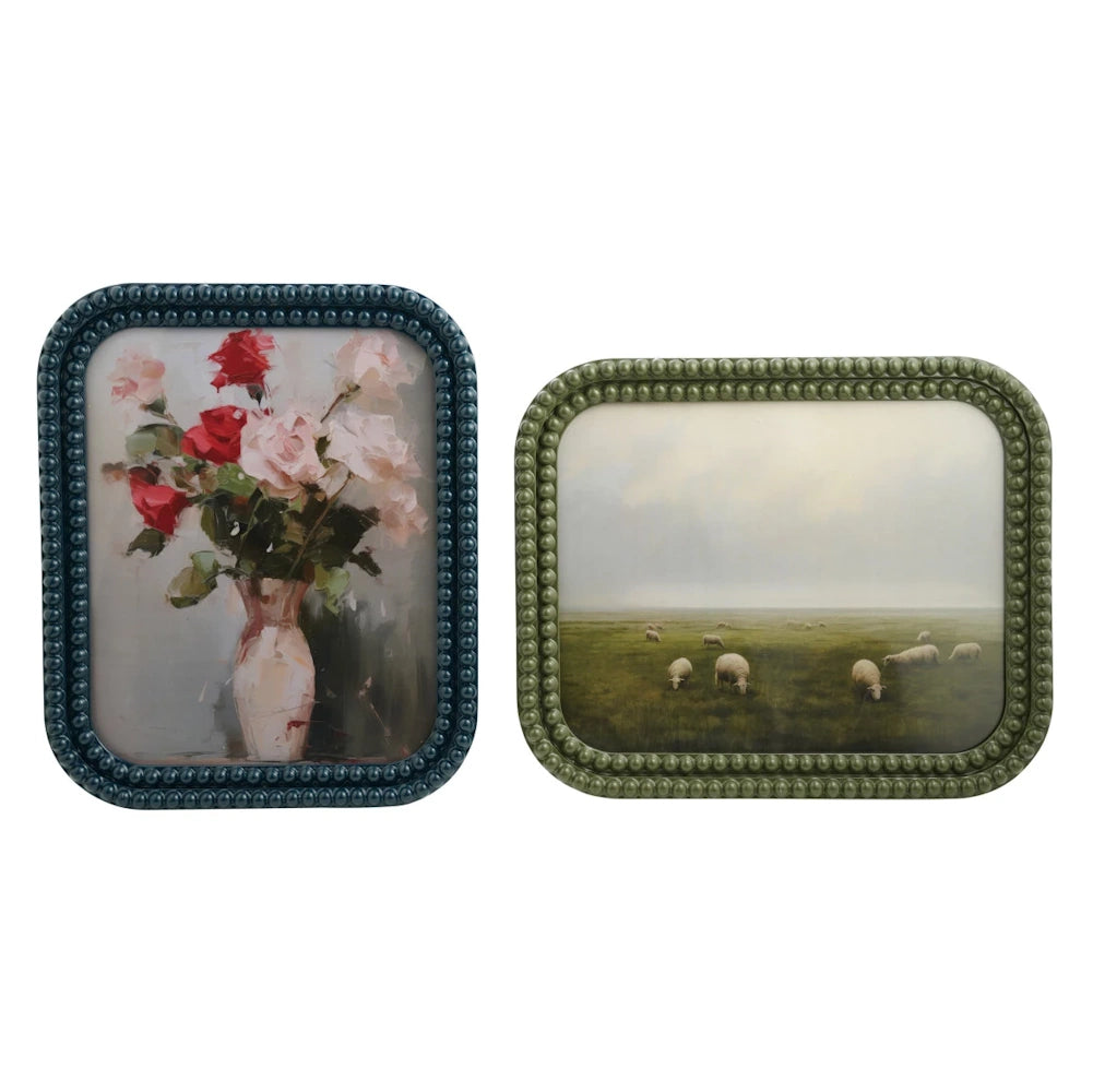 Two bobbin-style resin photo frames in blue and green, featuring a rose bouquet and a landscape with sheep.