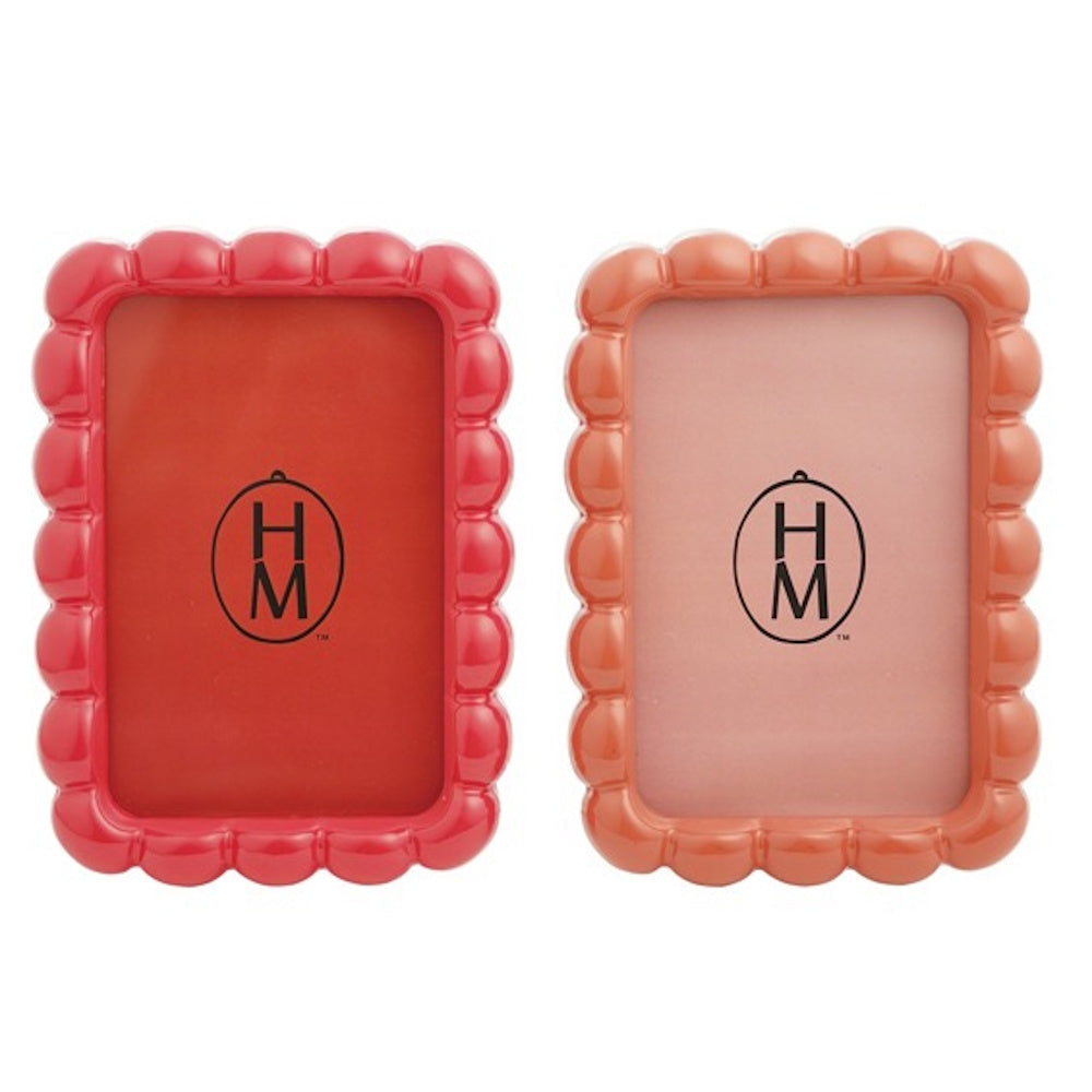 Two glossy, scalloped resin photo frames in red and peach-orange, side-by-side on a white background.