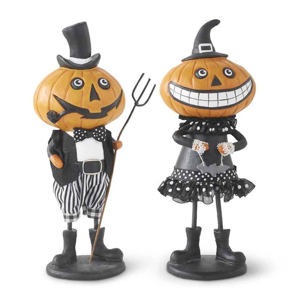 Two vintage-style Halloween pumpkin figurines dressed in black and white outfits on a white background.