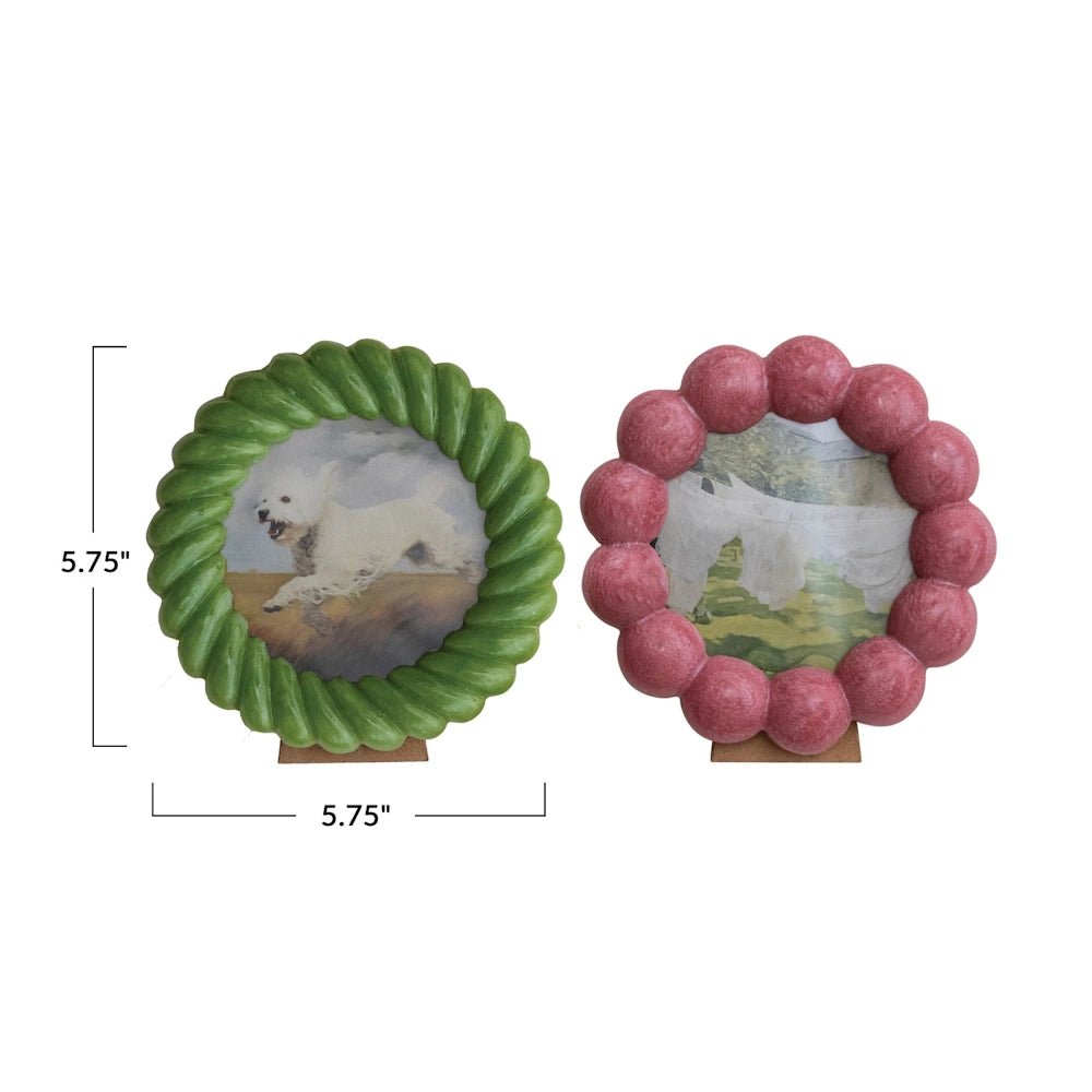Set of two 5.75-inch round scalloped resin photo frames in green rope and pink bubble designs with easel backs.