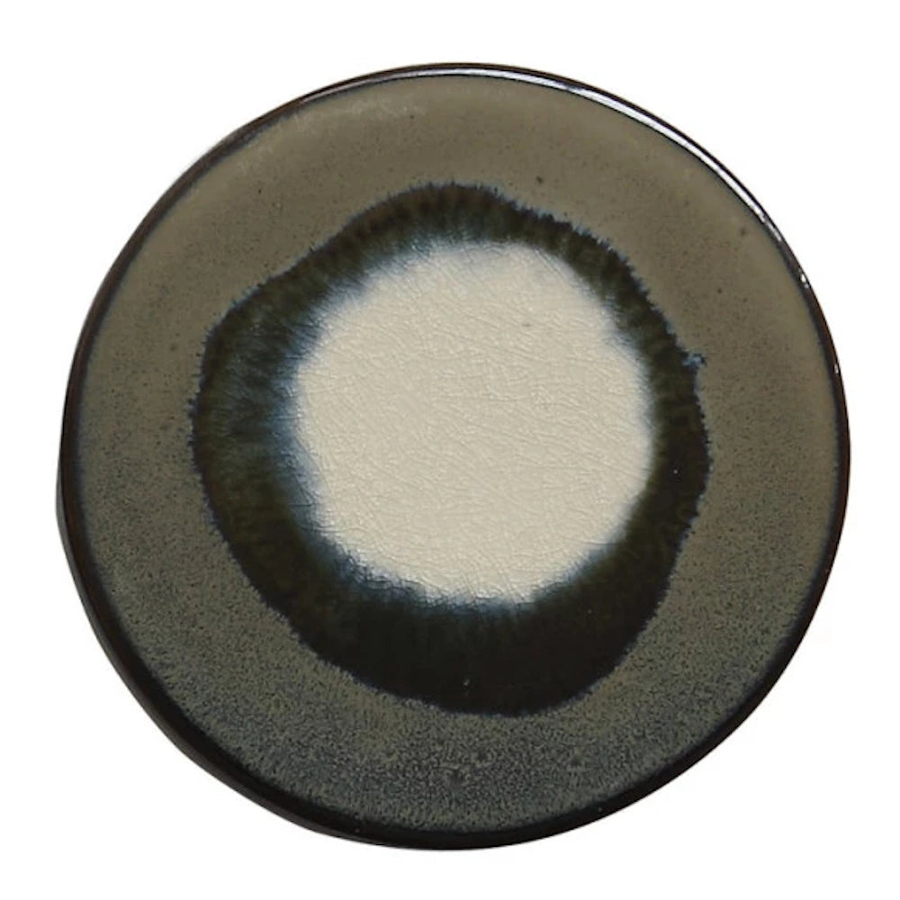 Round stoneware trivet with a dark grey and white reactive glaze finish, ideal for heat-resistant kitchen decor.