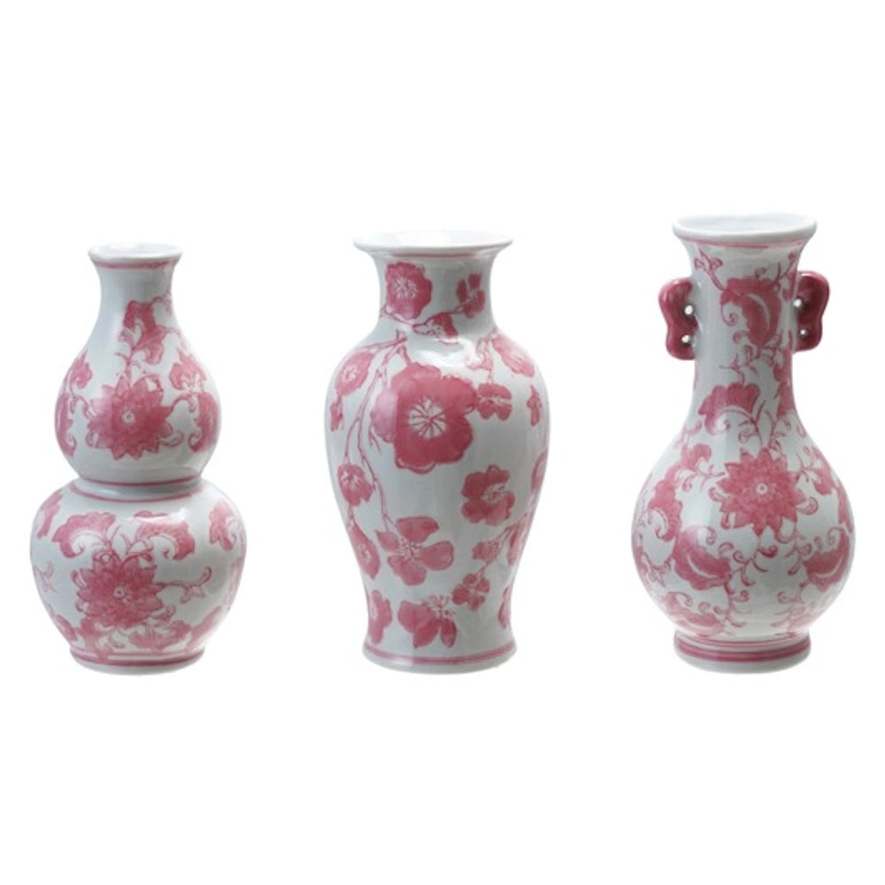 Set of three white stoneware vases with pink floral patterns in various shapes.