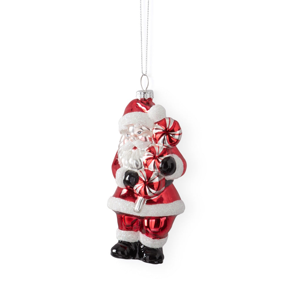 A hanging vintage glass Santa ornament holding round peppermint candies.