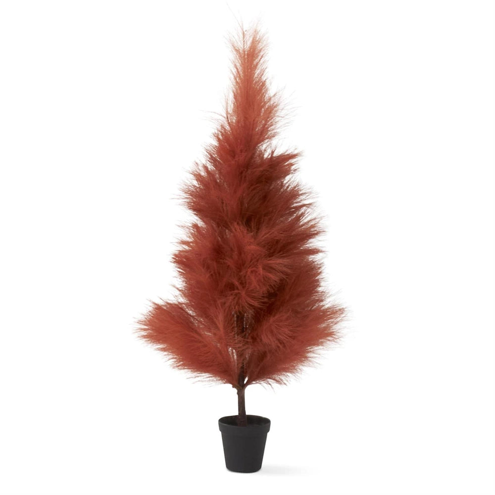 A small, fluffy rust-colored artificial tree in a black pot on a white background.