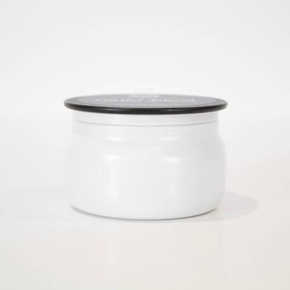 Small white candle tin with a black lid centered on a plain white background.