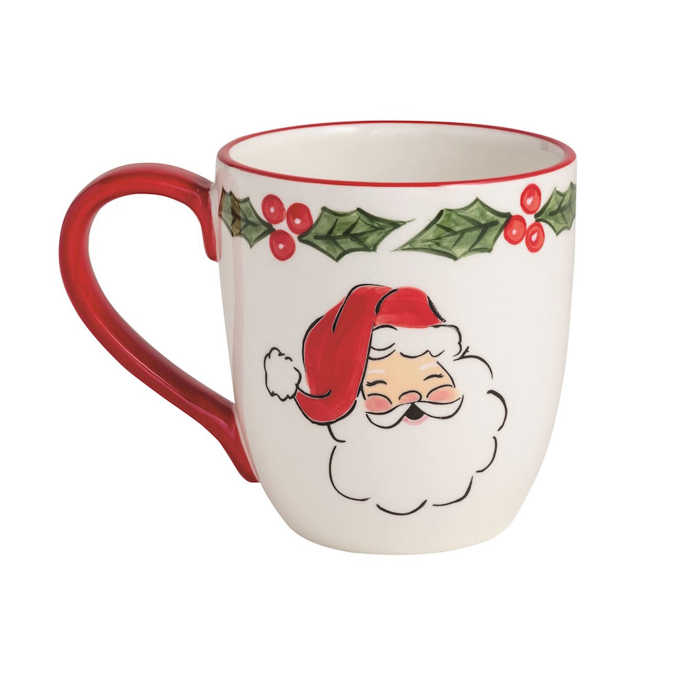 White ceramic mug with a painted Santa Claus face and holly leaf trim along the rim.