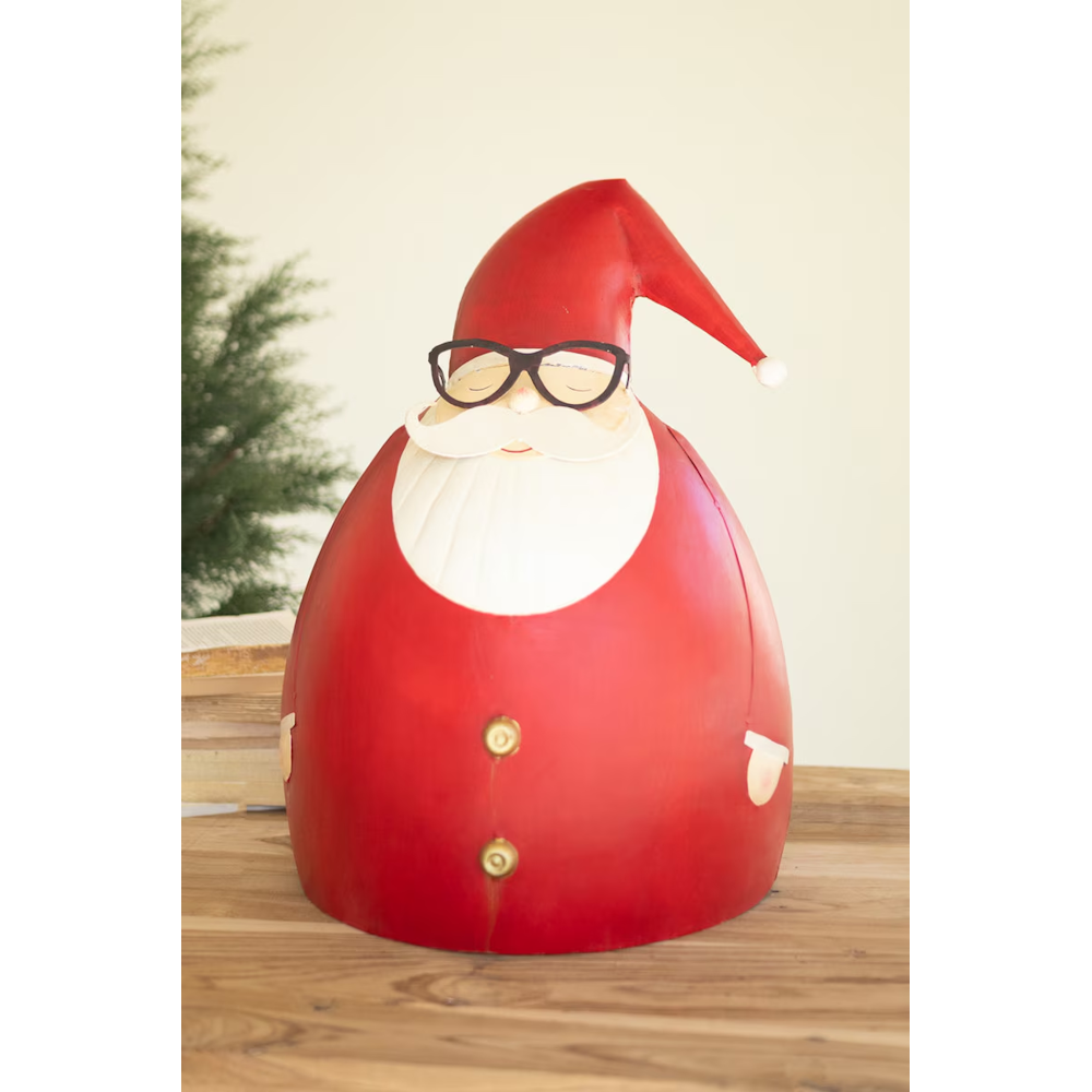 Front view of a rounded painted metal Santa sculpture on a wooden surface.