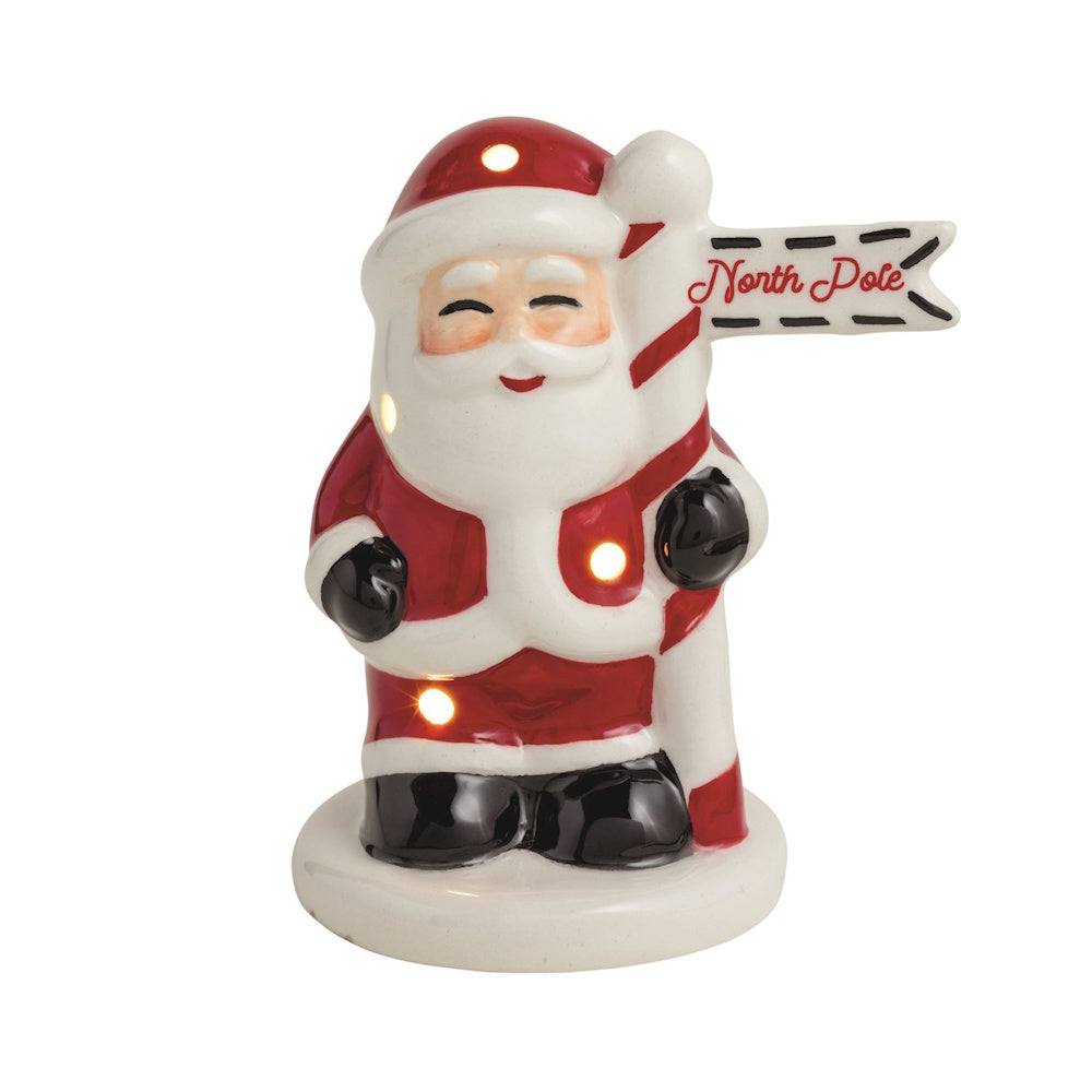 Glowing ceramic Santa figurine holding a North Pole sign.