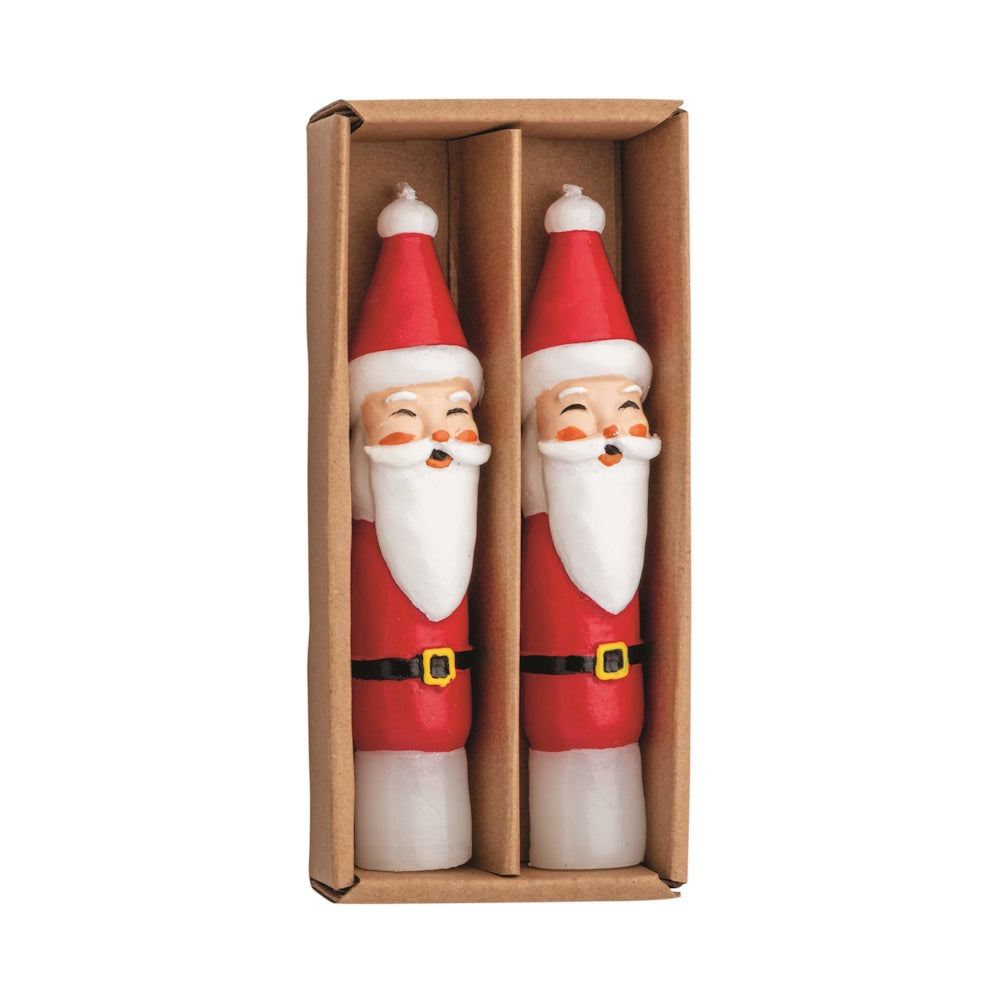 Flat lay view of two red and white wax Santa mini taper candles in a brown cardboard box.