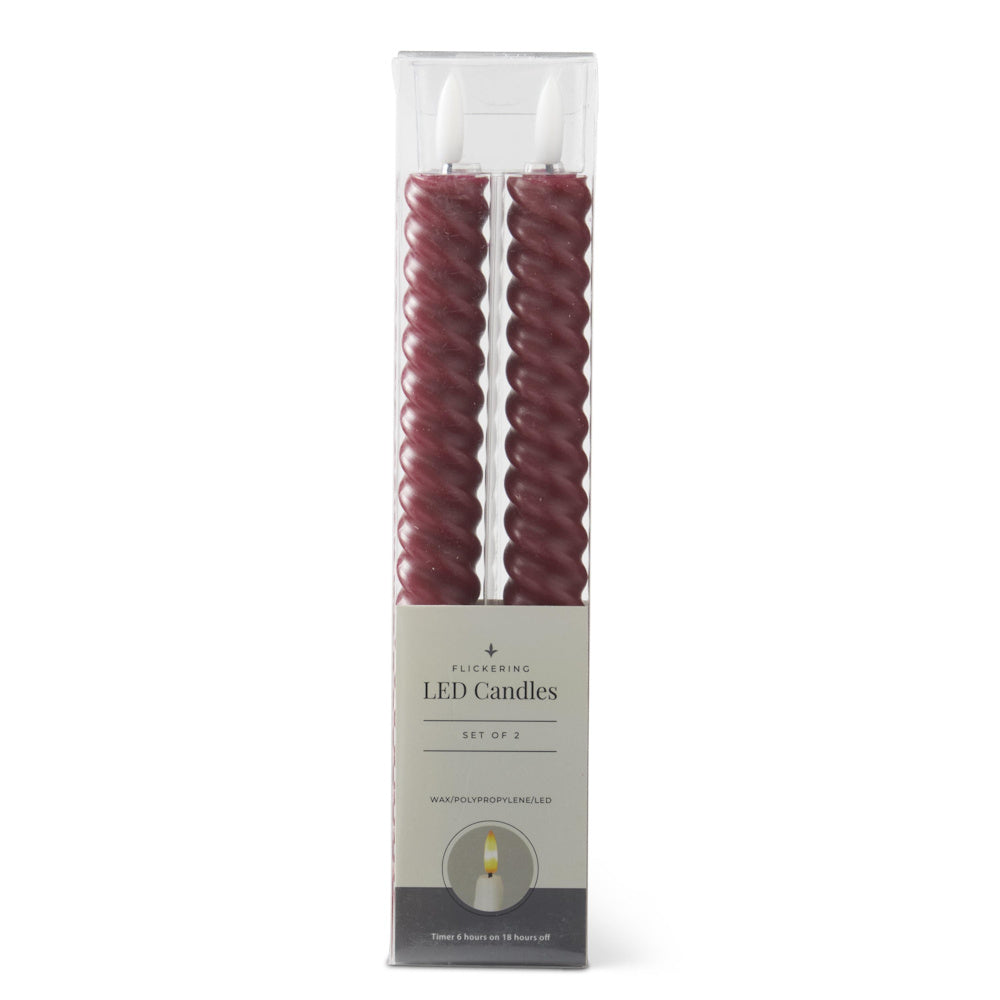 A set of two burgundy, spiral-twisted flickering LED taper candles in their original box packaging.