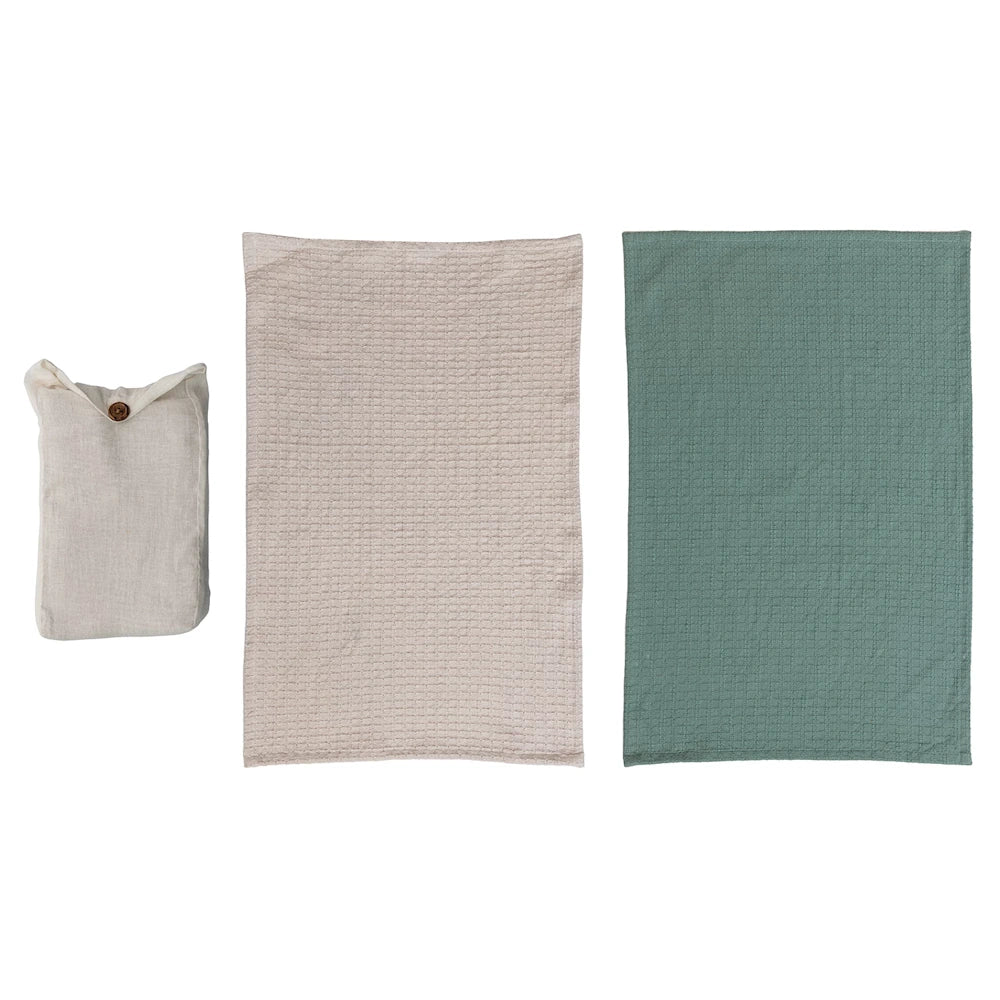 Set of 2 cotton waffle weave tea towels in cream and sage green, shown with matching buttoned fabric storage pouch.