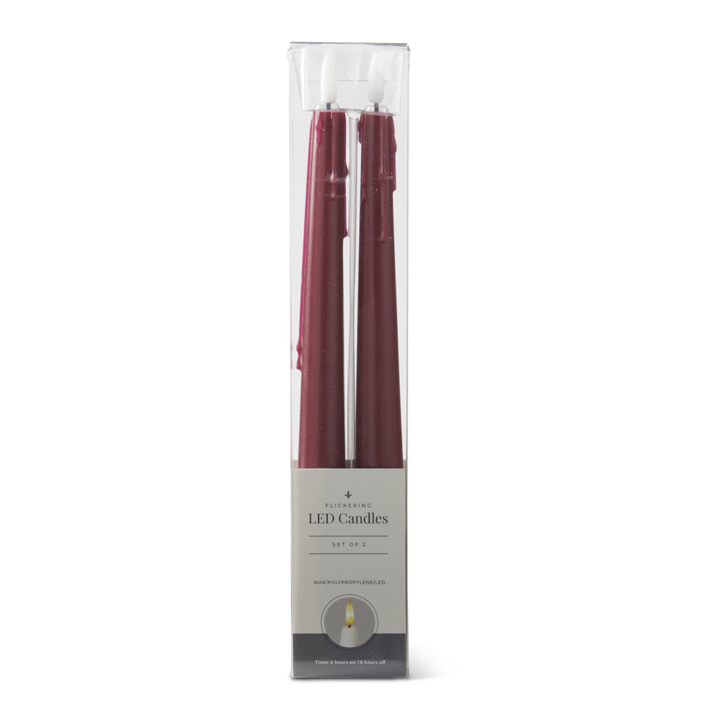 A pack of two burgundy, faux-drip LED taper candles in clear packaging.