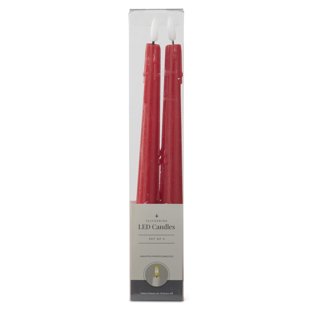 A pair of red flickering LED taper candles packaged inside a clear plastic box with a grey cardboard base.
