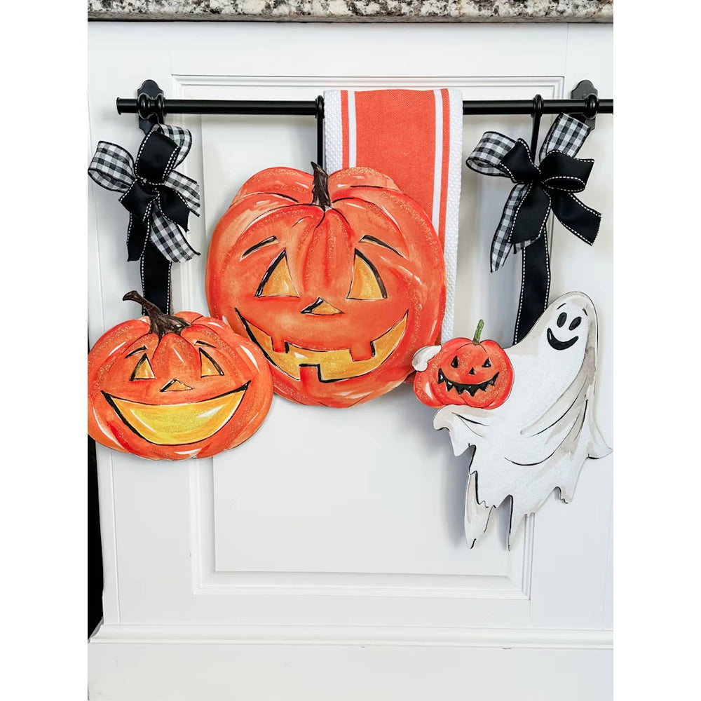 Set of two smiling orange jack o lantern Halloween yard stakes displayed as kitchen cabinet door hangers.