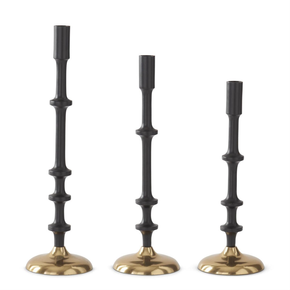 Set of 3 modern matte black taper candle holders with gold brass bases in varying heights.