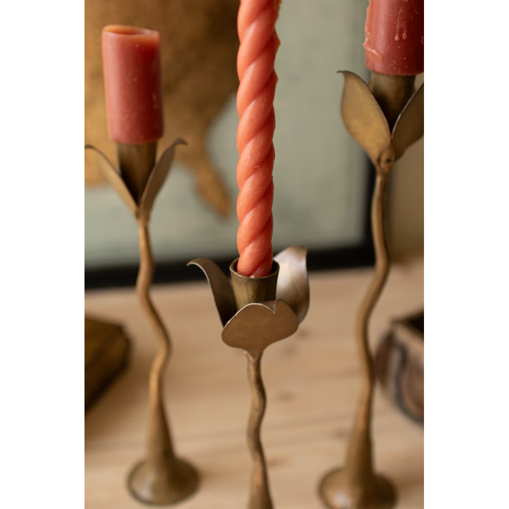 Close-up of leaf-shaped candle cups and organic stems on brass forged iron taper candle holders.