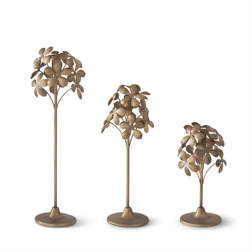 Set of 3 gold metal floral taper candle holders in varied heights, featuring textured flower petals on slender stems.