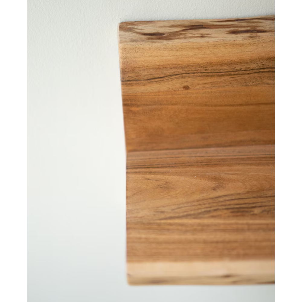 Close-up of natural wood grain and live-edge detail on a floating wooden shelf mounted to a wall.