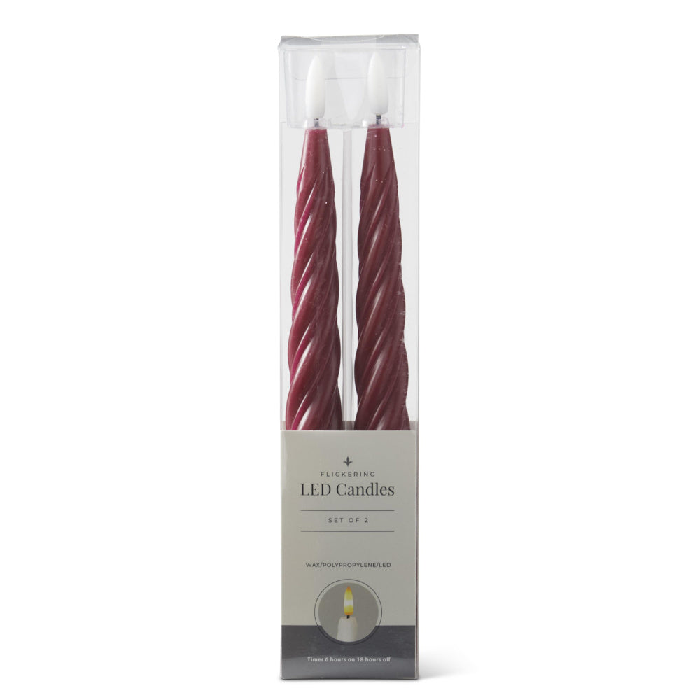 A set of two burgundy spiral LED taper candles in clear packaging.