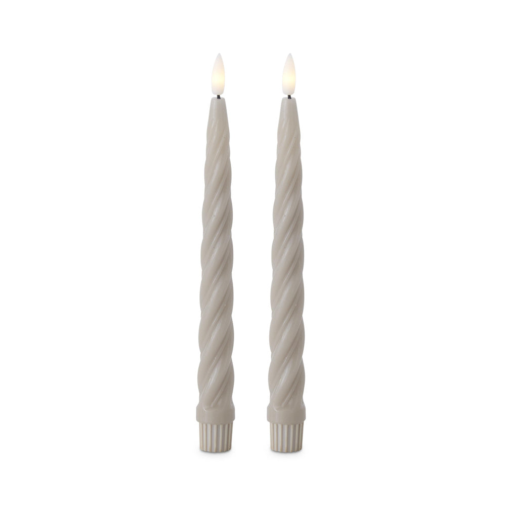 Two cream-colored spiral LED taper candles with glowing faux flames against a white background.