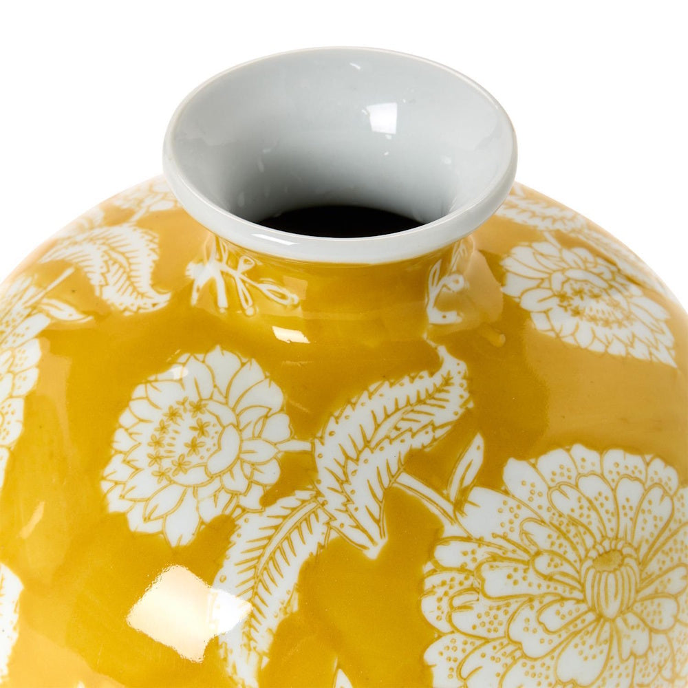 Top view of a round yellow ceramic vase with white floral patterns and a white rim.