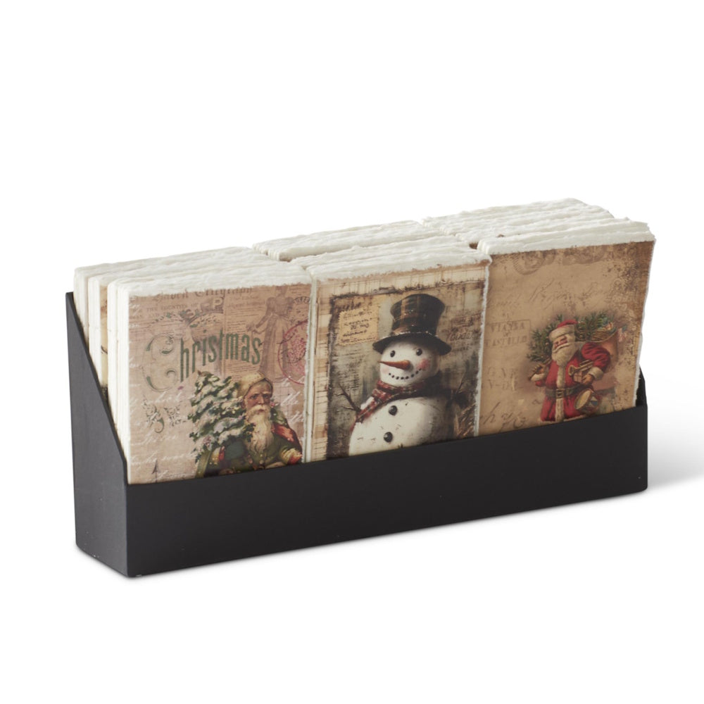 A black display holder filled with assorted soft-cover Christmas journals featuring deckle edges and vintage holiday illustrations.