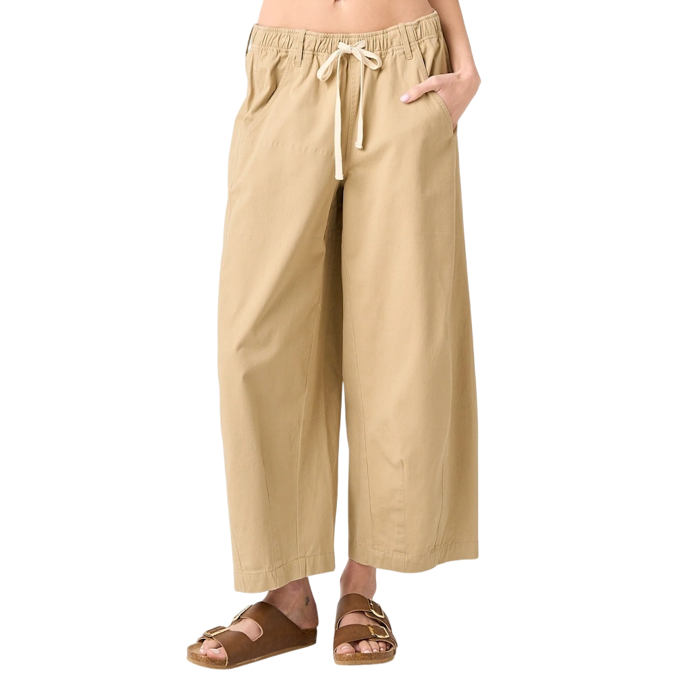 A person wearing khaki wide-leg barrel pants with a drawstring elastic waist and brown slide sandals.