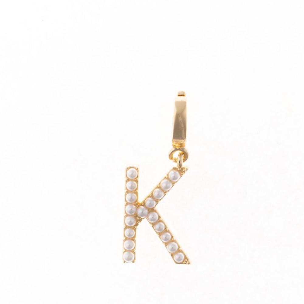 Gold letter 'K' charm studded with small white faux pearls on a plain white background.